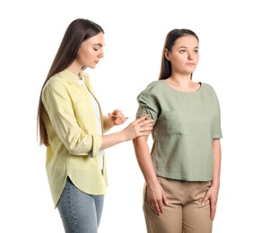 Woman giving insulin injection to her diabetic friend on white background