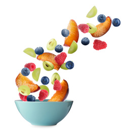 Fresh tasty fruits and berries falling into bowl on white background