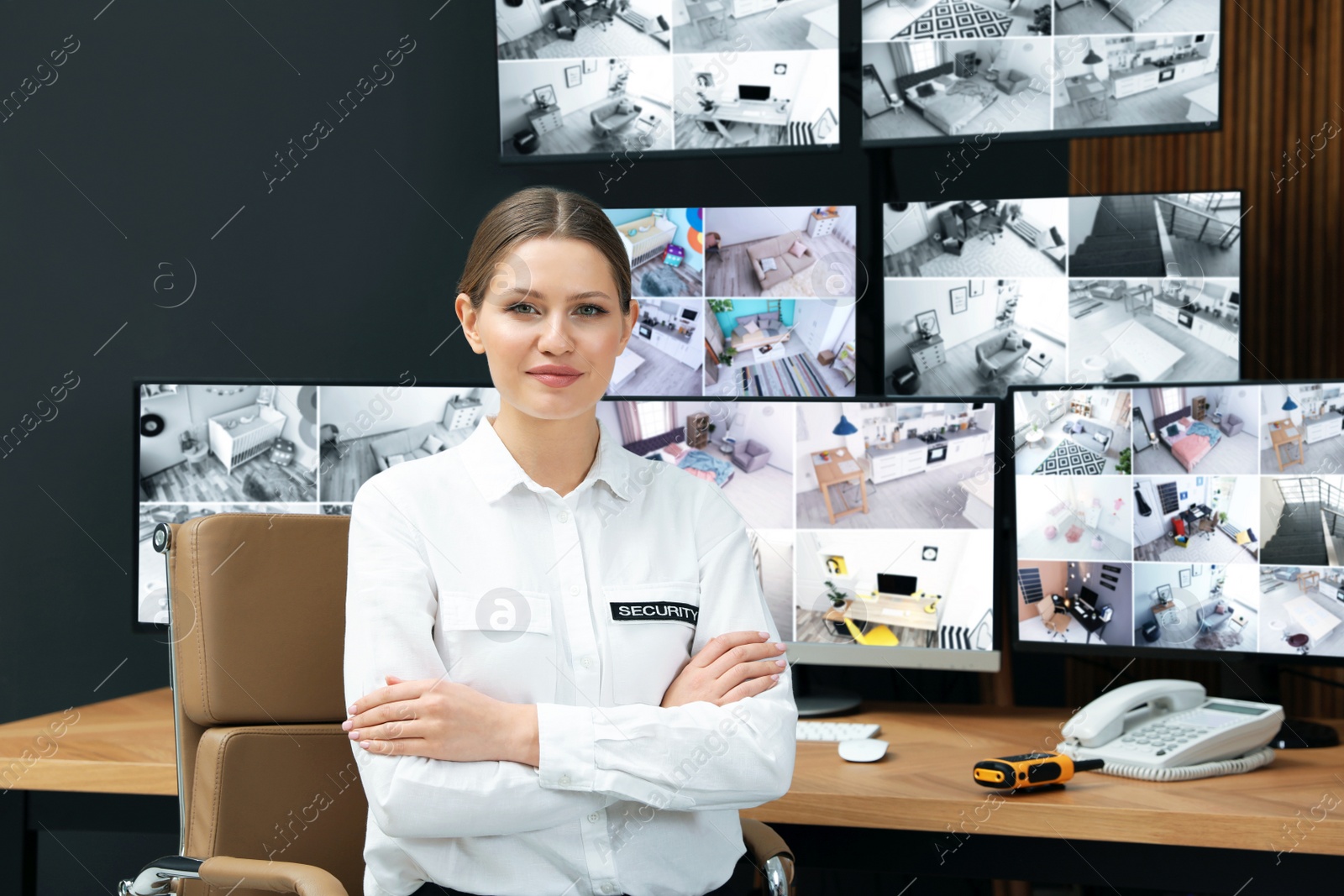 Photo of Security guard in uniform at workplace with monitors