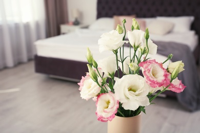 Photo of Beautiful flowers in vase and space for text on blurred background. Element of interior design