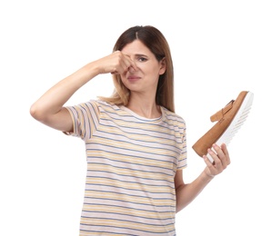 Photo of Woman feeling bad smell from shoe on white background. Air freshener