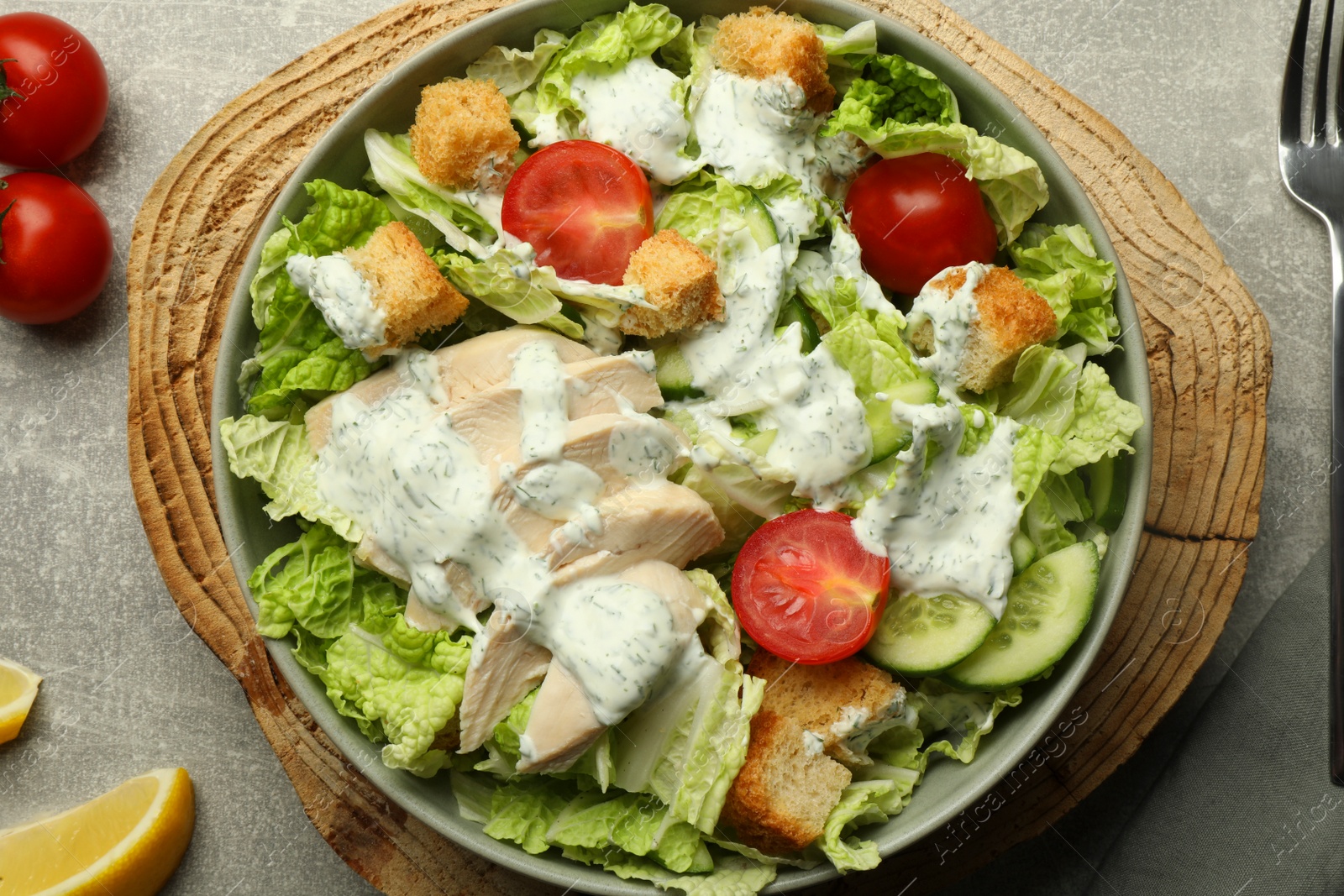 Photo of Delicious salad with Chinese cabbage, cucumber, meat and tomatoes served on grey table, flat lay