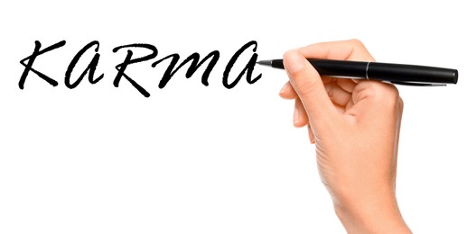 Woman writing word KARMA on white background, closeup, Banner design