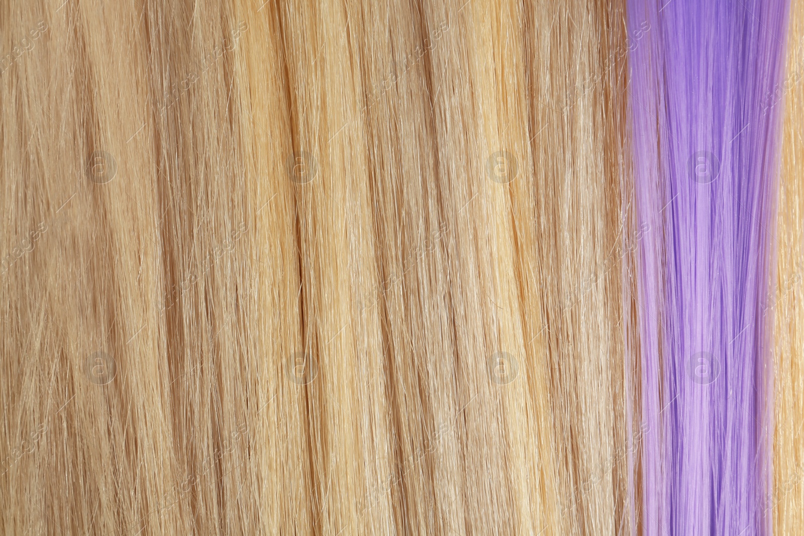 Photo of Strands of blond and violet hair as background, closeup