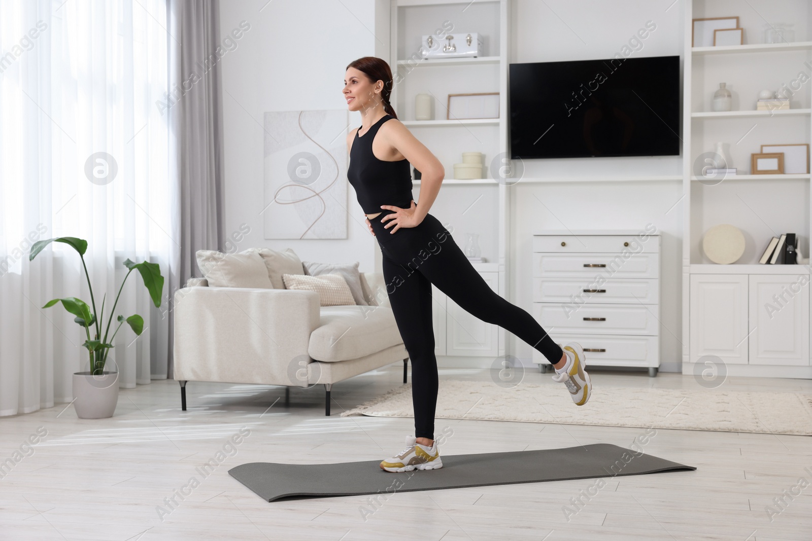 Photo of Happy woman doing morning exercise at home