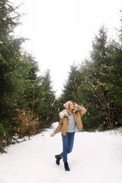 Young woman in snowy conifer forest. Winter vacation