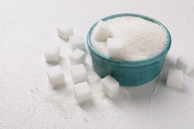 Different types of sugar in bowl on white table, closeup. Space for text