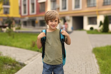 Photo of Cute little boy walking to kindergarten outdoors