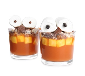 Photo of Glasses with delicious dessert decorated as monsters on white background. Halloween treat