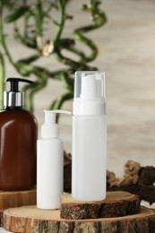 Bottles of face cleansing products on wooden stand