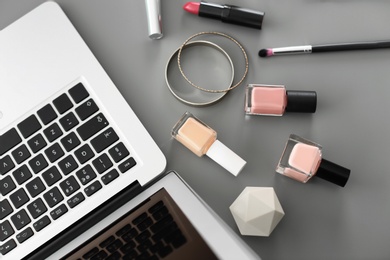 Photo of Makeup products for woman and laptop on table