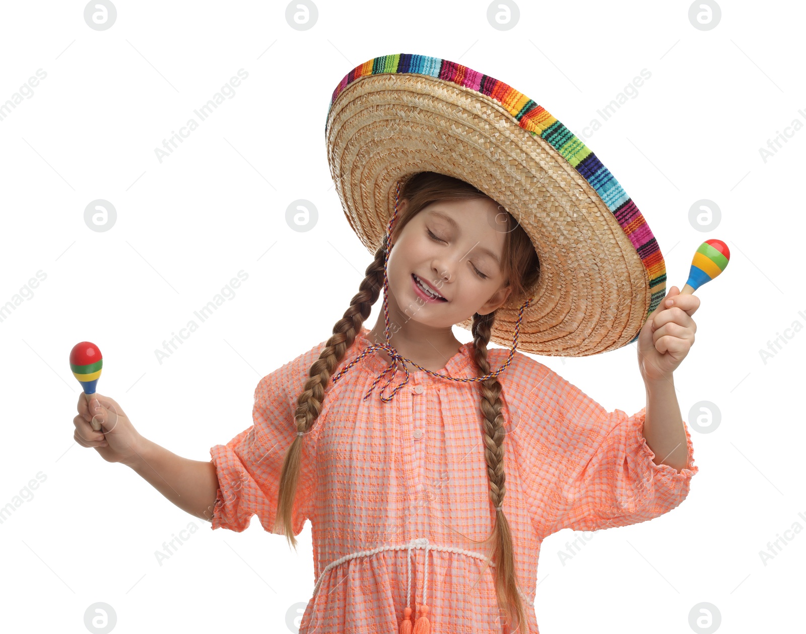 Photo of Cute girl in Mexican sombrero hat dancing with maracas on white background