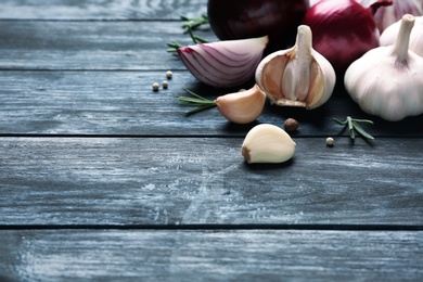 Photo of Composition with garlic and onions on wooden background. Space for text