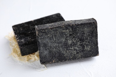 Photo of Natural tar soap on white background, closeup