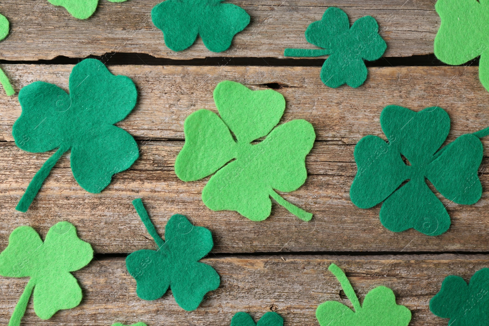 Photo of St. Patrick's day. Decorative clover leaves on wooden background, flat lay