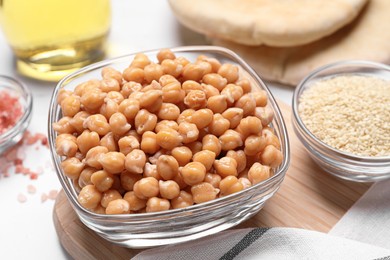 Photo of Delicious chickpeas and different products on white table. Hummus ingredients
