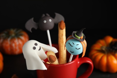 Photo of Different cake pops in cup decorated as monsters, closeup. Halloween treat