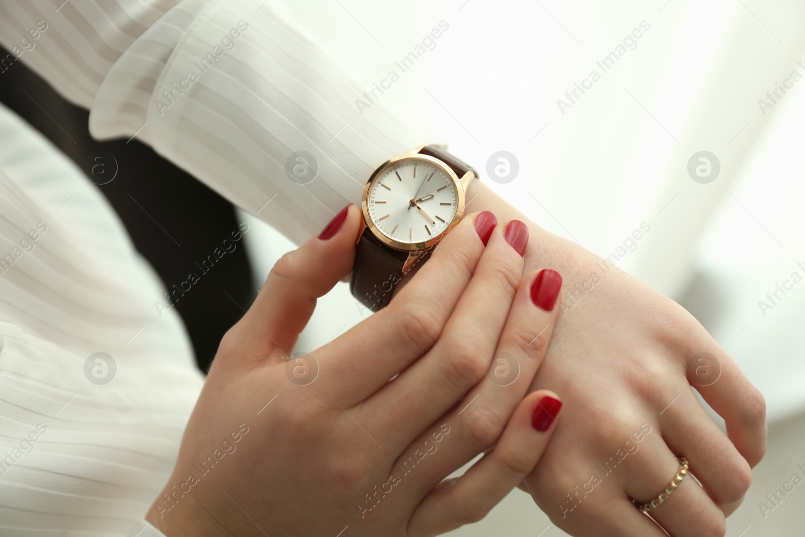 Photo of Woman wearing luxury wristwatch indoors, closeup of hand