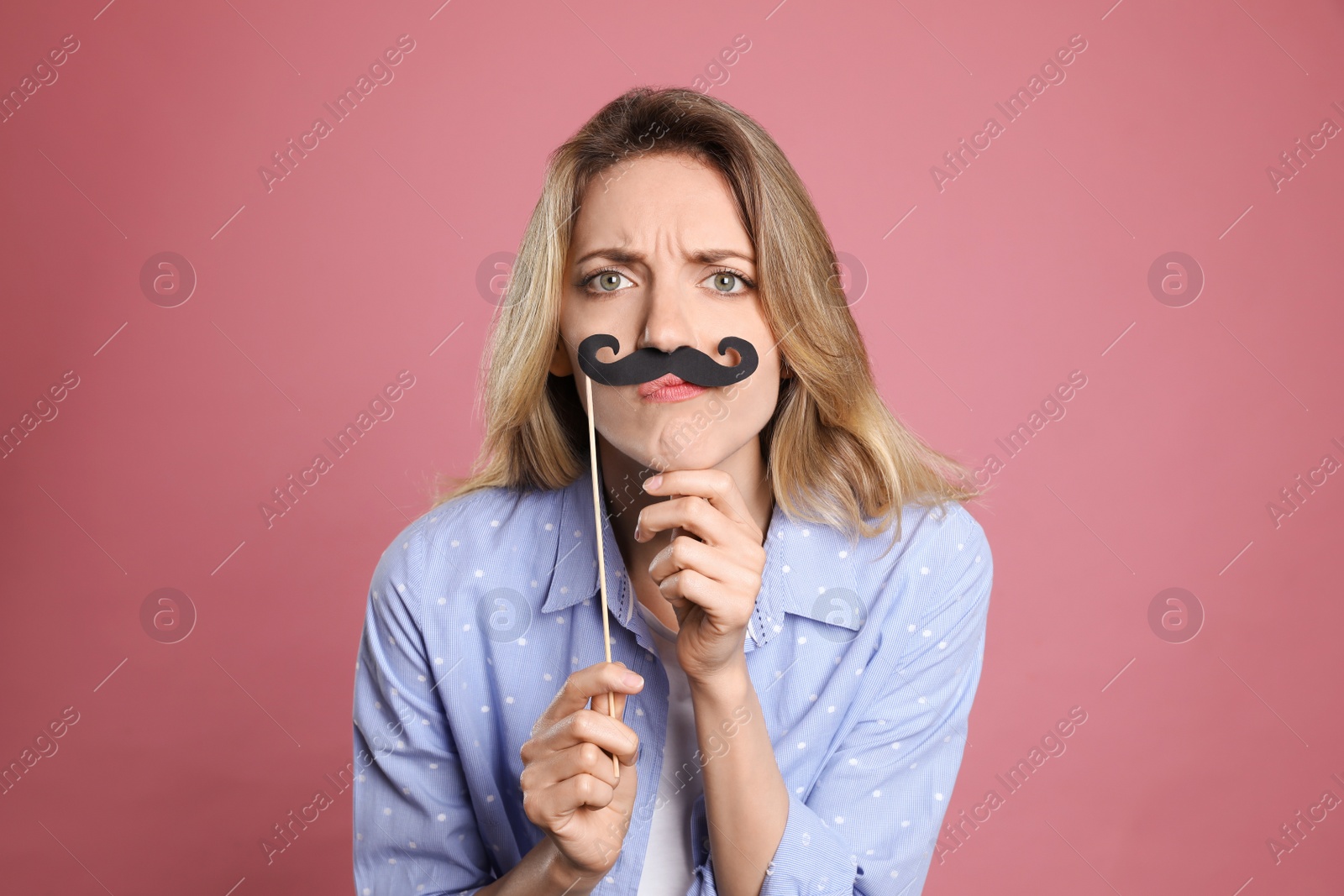 Photo of Funny woman with fake mustache on dusty rose background