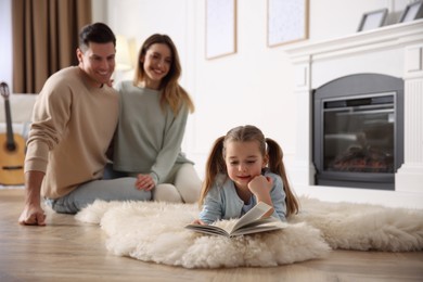 Photo of Happy family resting near fireplace at home