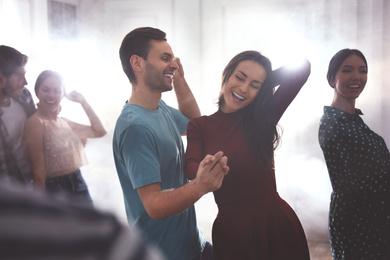 Photo of Lovely young couple dancing together at party