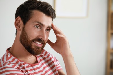 Portrait of handsome bearded man at home, space for text