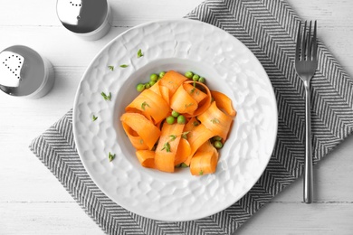 Tasty salad with fresh carrot in plate on table, top view