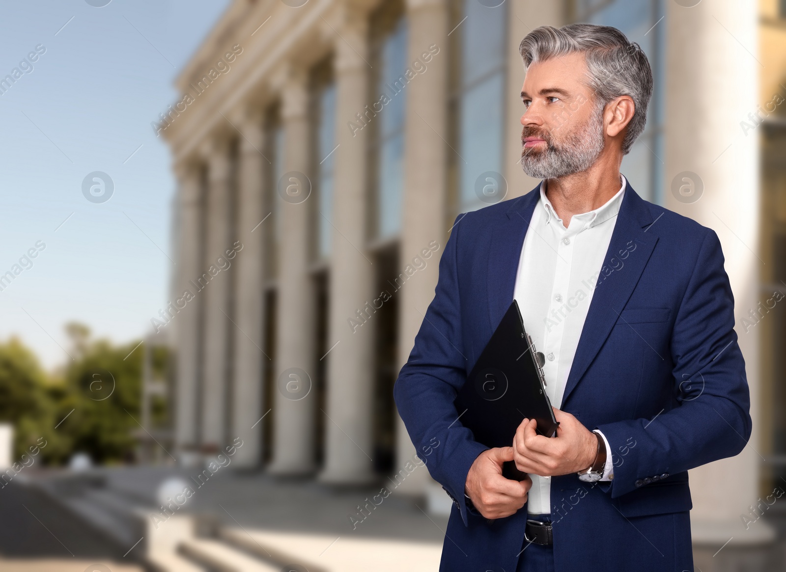 Image of Successful lawyer with clipboard near building outdoors, space for text