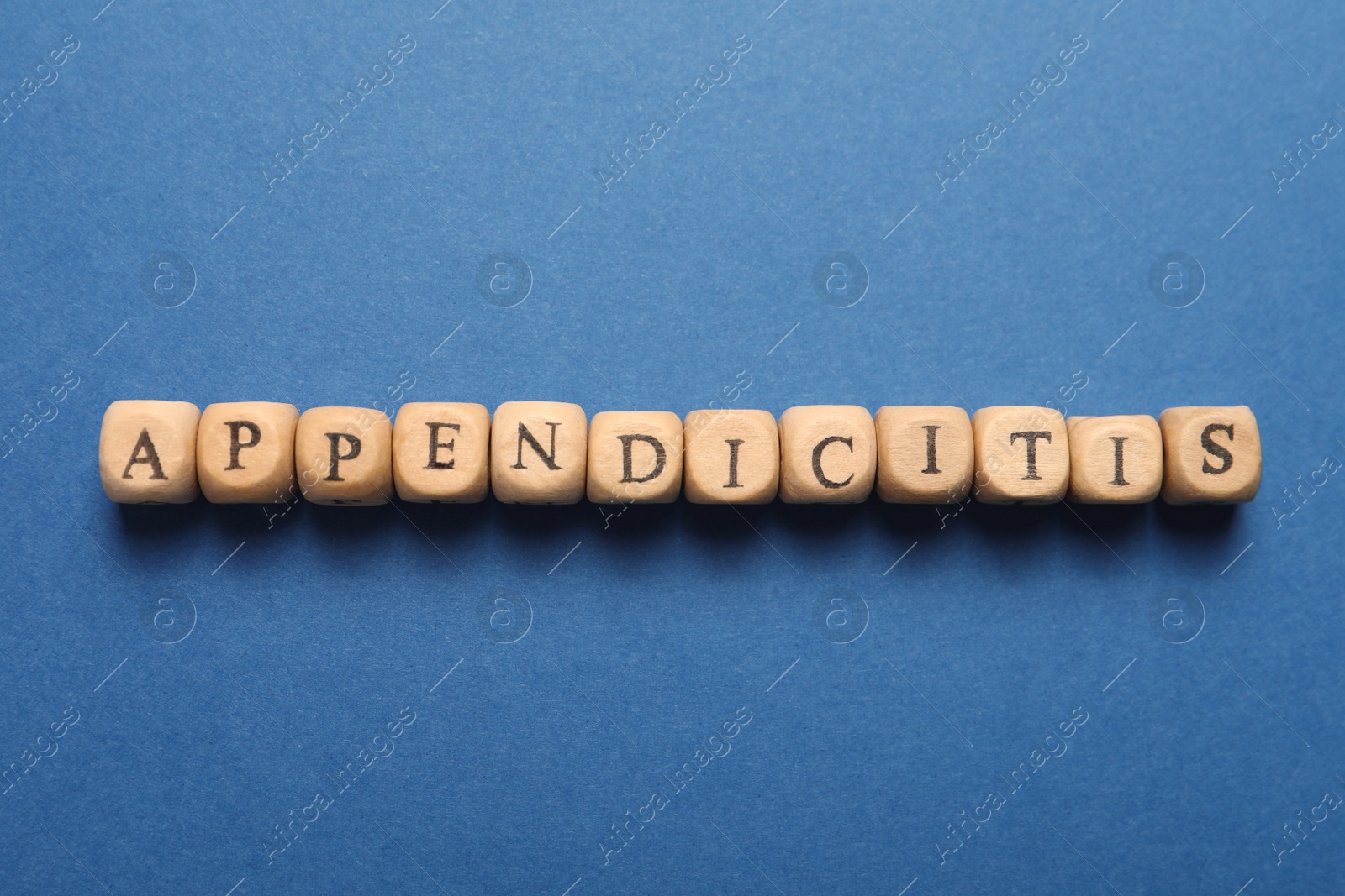 Photo of Word Appendicitis made of wooden cubes with letters on blue background, top view