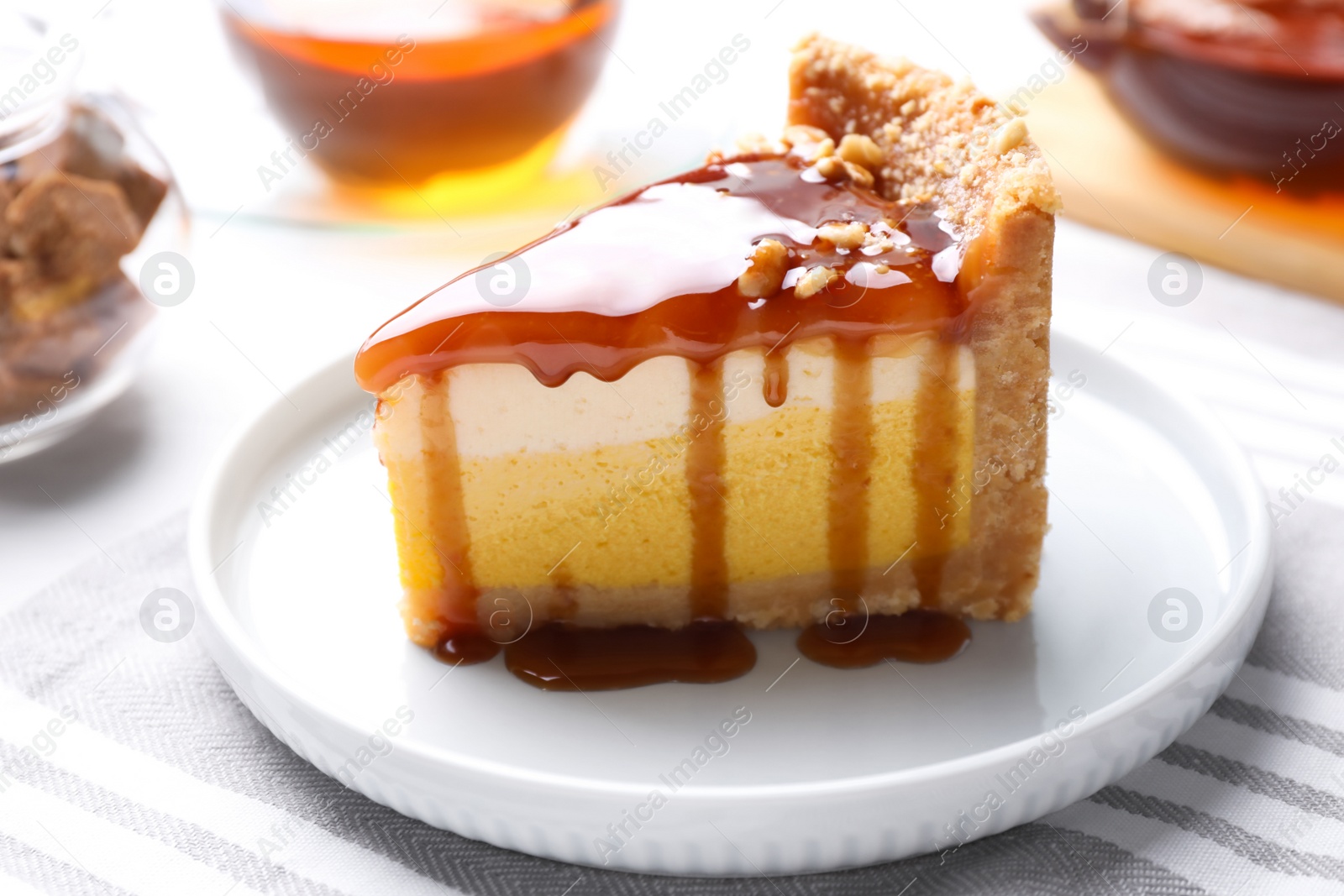 Photo of Slice of delicious cake with caramel sauce on table