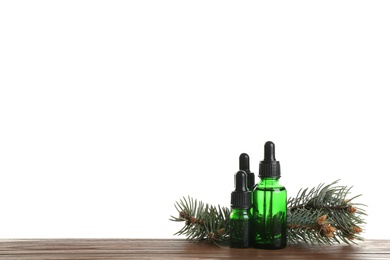 Composition with bottles of conifer essential oil on table against white background. Space for text