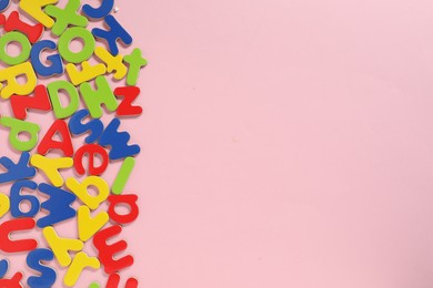 Learning alphabet. Magnetic letters on pink background, flat lay. Space for text