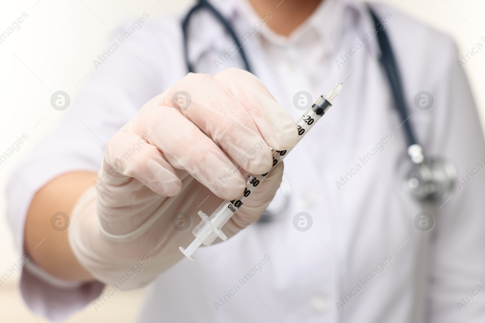 Photo of Doctor holding medical syringe on white background, closeup