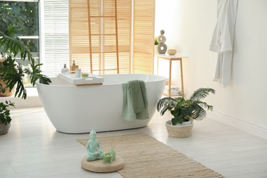 Stylish bathroom interior with modern tub and beautiful houseplants