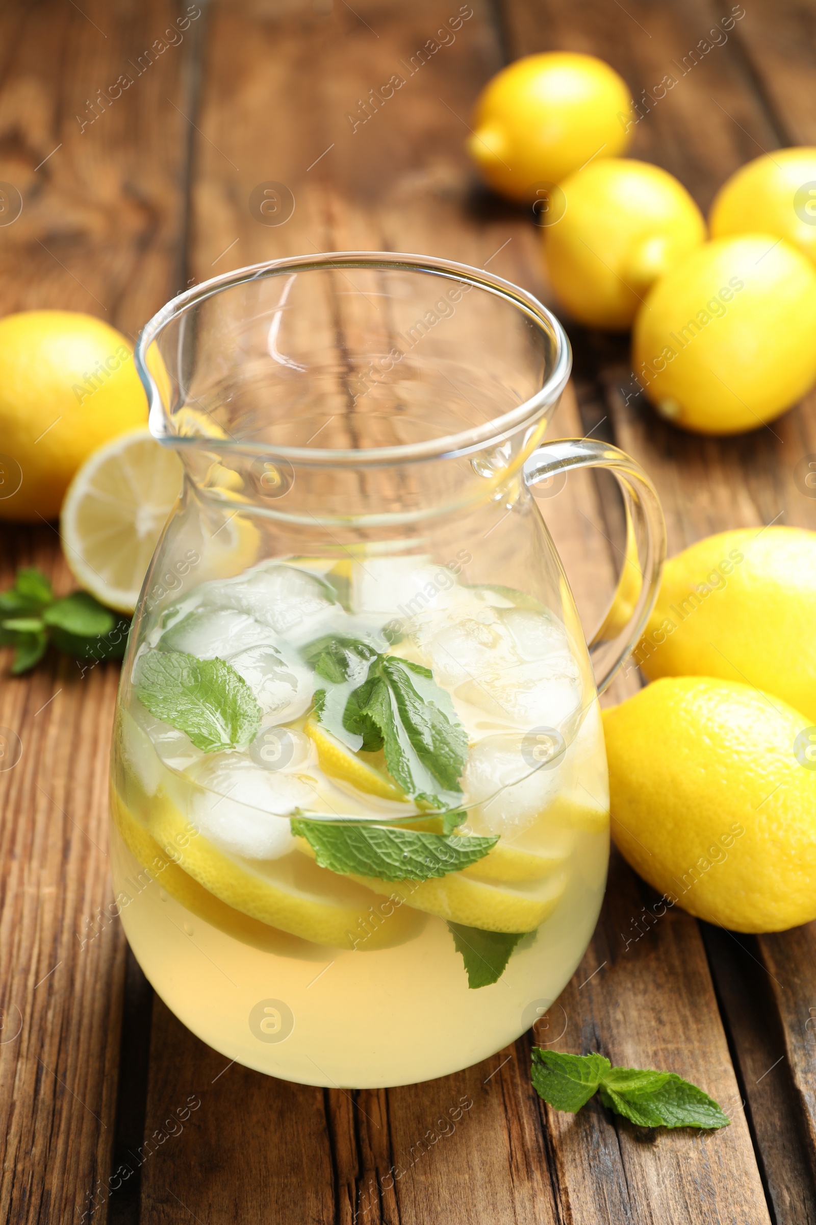 Photo of Natural lemonade with mint and fresh fruits on wooden table. Summer refreshing drink
