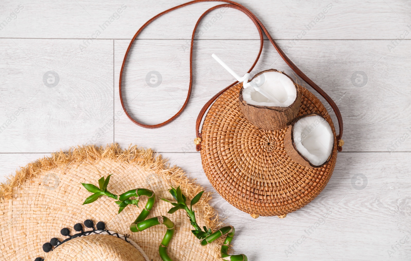 Photo of Flat lay composition with bamboo bag and straw hat on wooden background