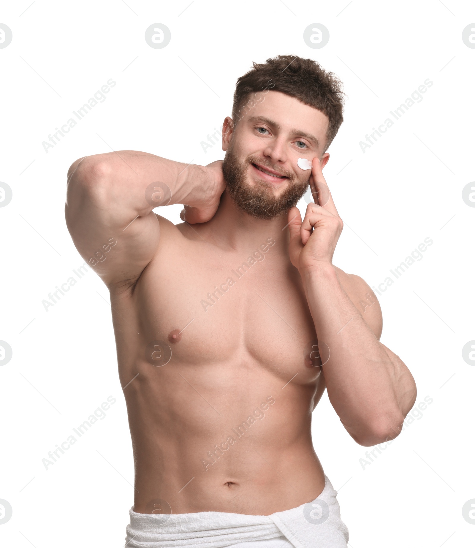 Photo of Handsome man applying moisturizing cream onto his face on white background