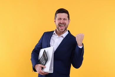 Photo of Emotional accountant with calculator and folder on yellow background