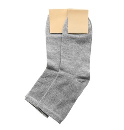 Photo of New pairs of grey cotton socks on white background, top view