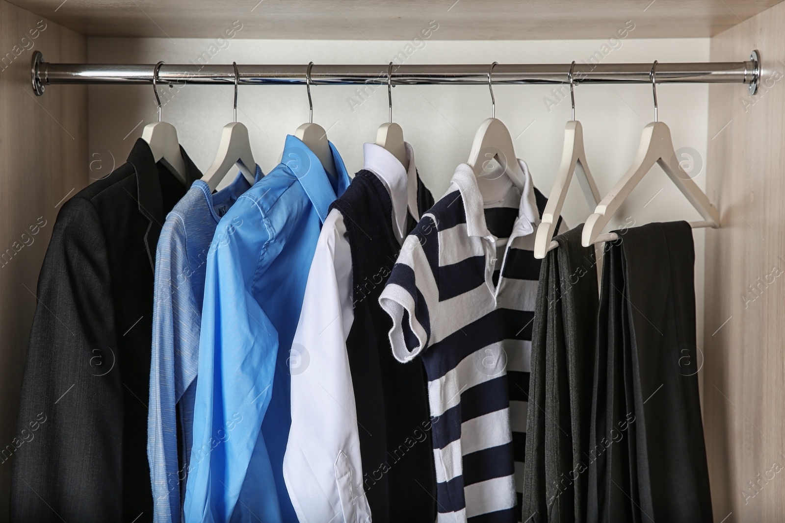 Photo of Wardrobe with stylish boy's clothes hanging on rack