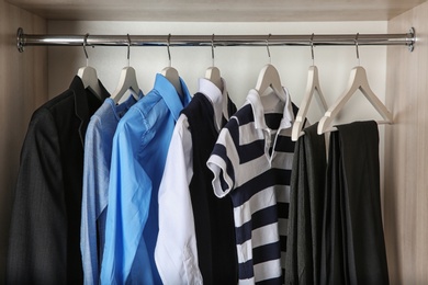 Wardrobe with stylish boy's clothes hanging on rack