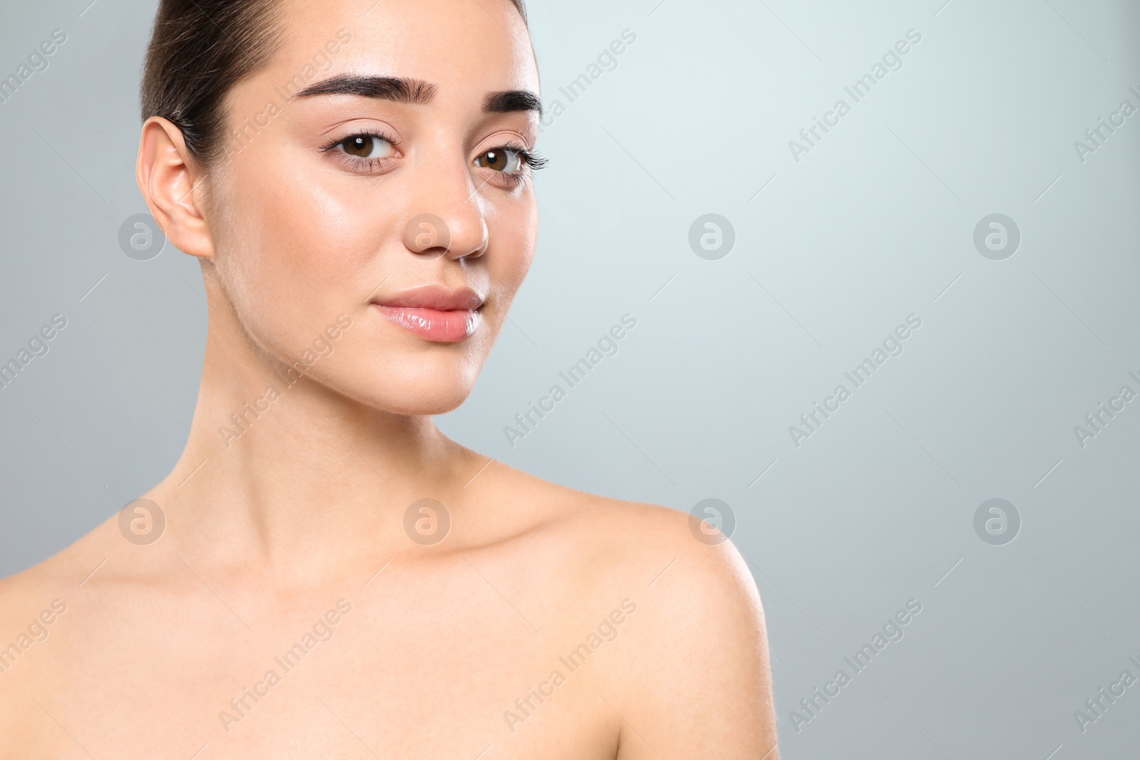 Photo of Portrait of young woman with beautiful face against color background. Space for text