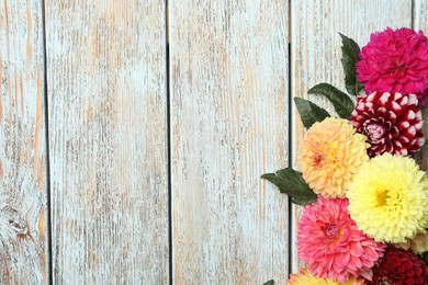 Photo of Beautiful dahlia flowers on wooden background, flat lay. Space for text