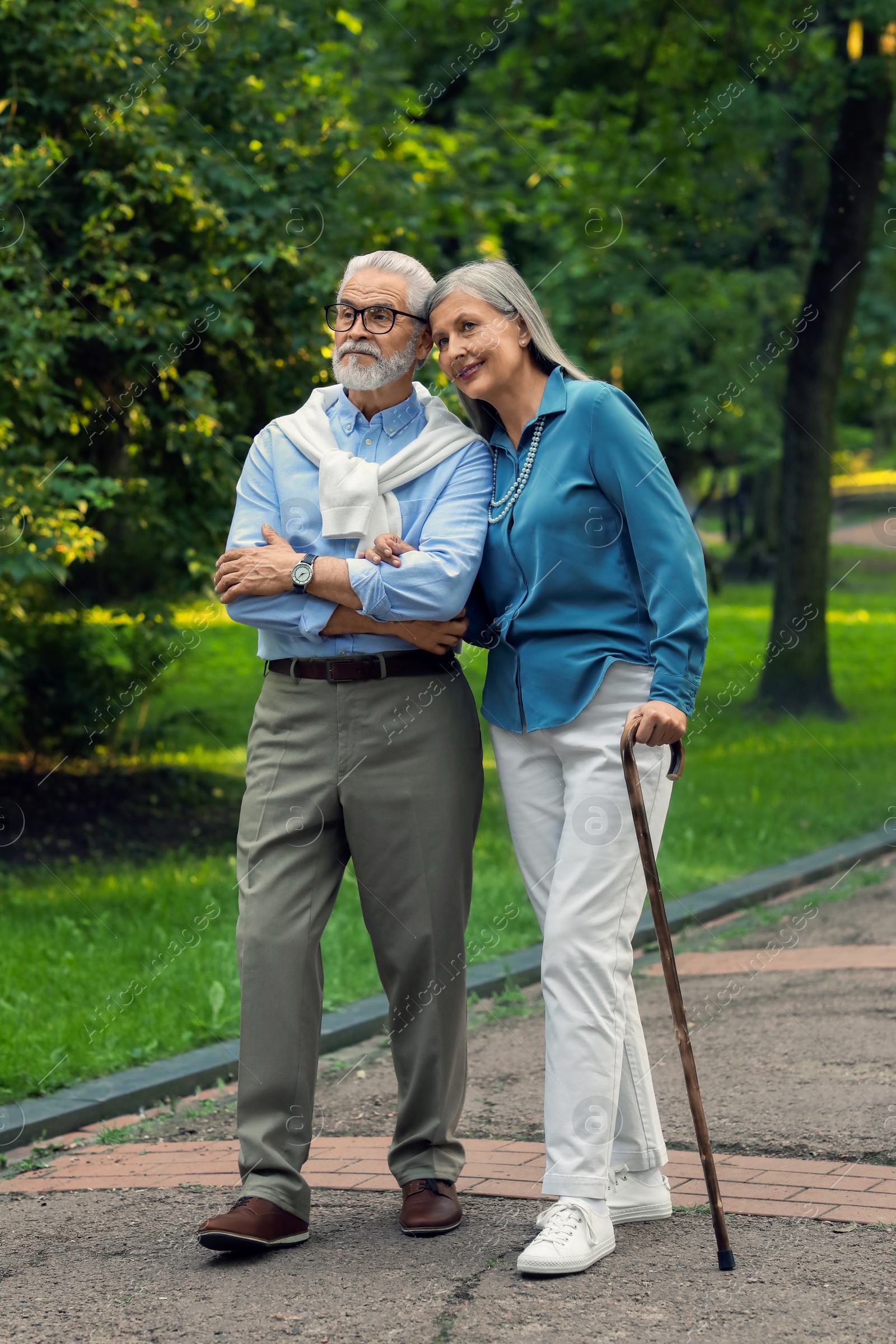 Photo of Senior man with walking cane and mature woman in park