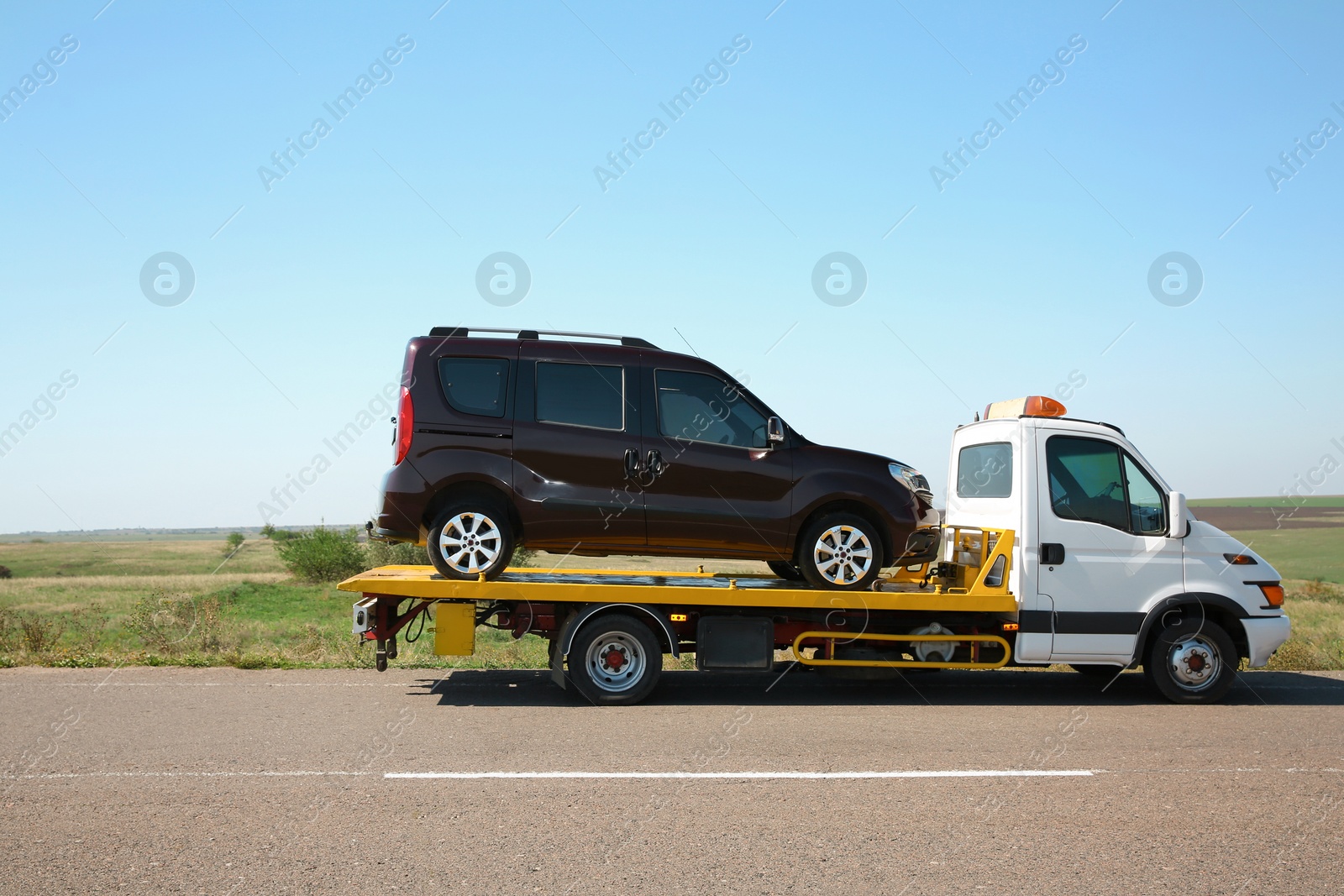 Photo of Tow truck with broken car on country road