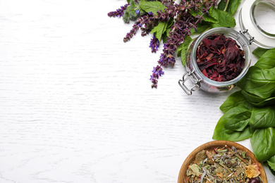 Photo of Flat lay composition with different healing herbs on white wooden table, space for text