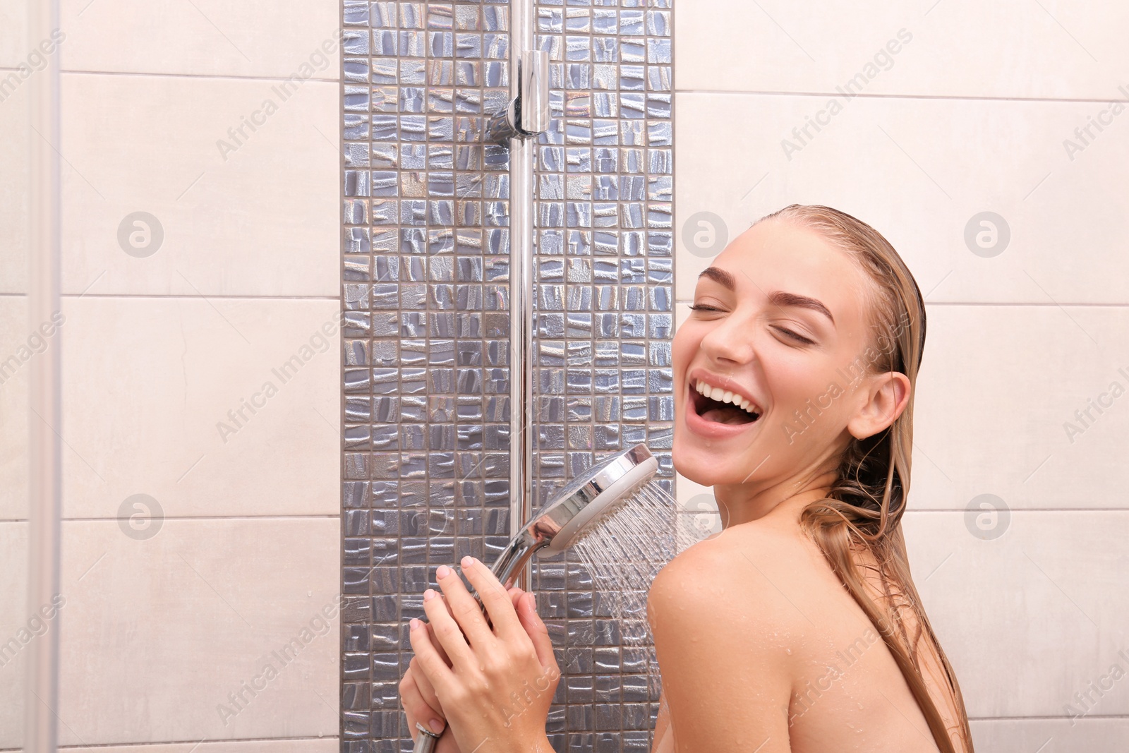 Photo of Beautiful young woman singing in shower at home