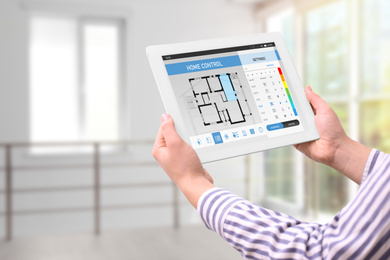 Image of Woman using energy efficiency home control system on tablet, closeup
