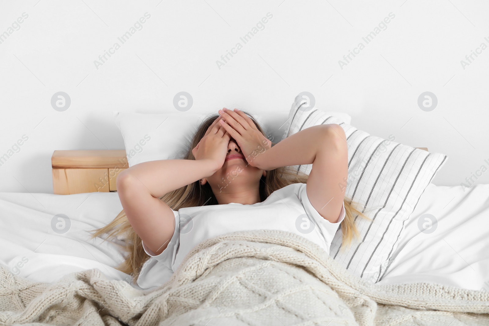 Photo of Sleepless young woman in bed at home