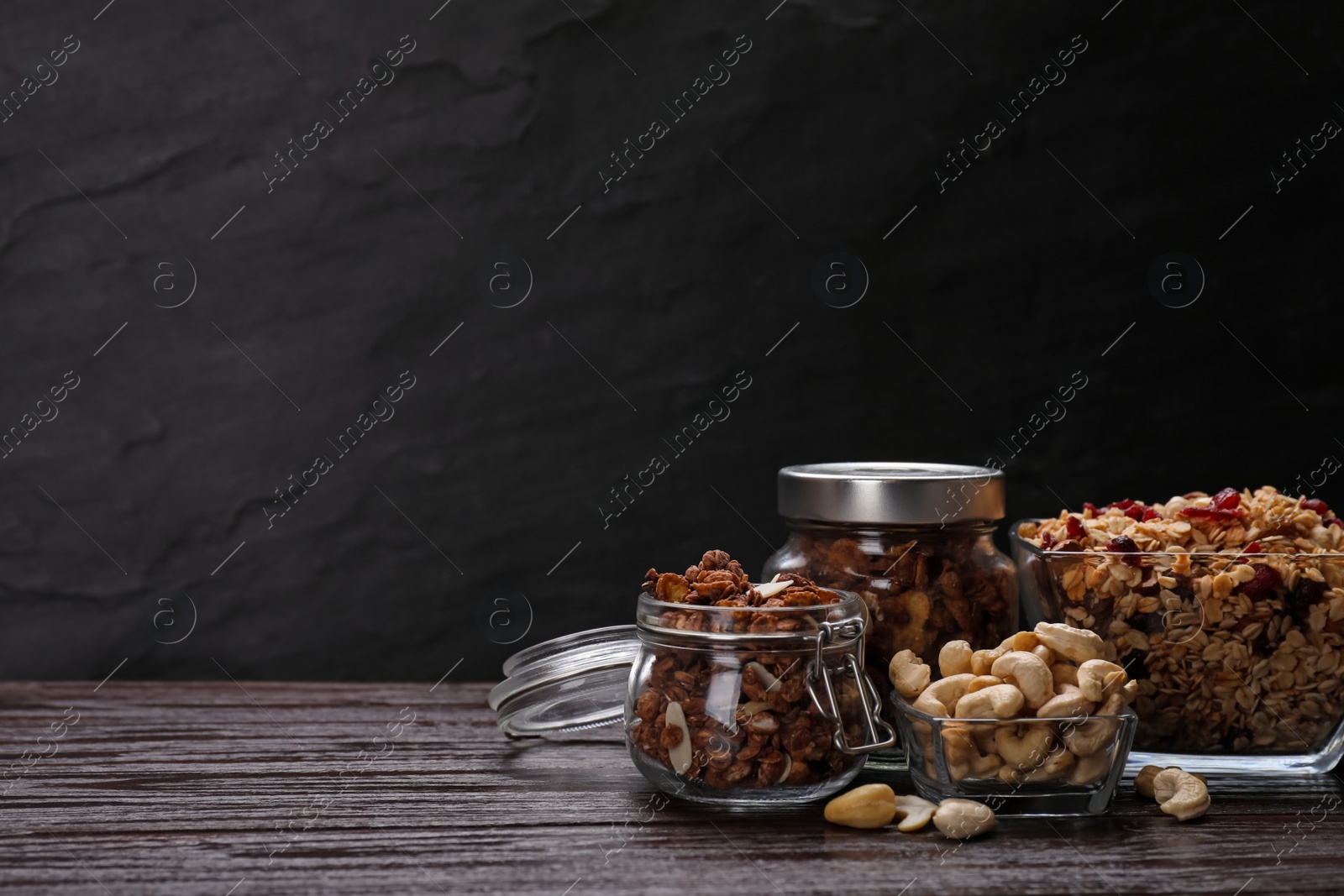 Photo of Tasty granola with nuts and dry fruits on wooden table. Space for text